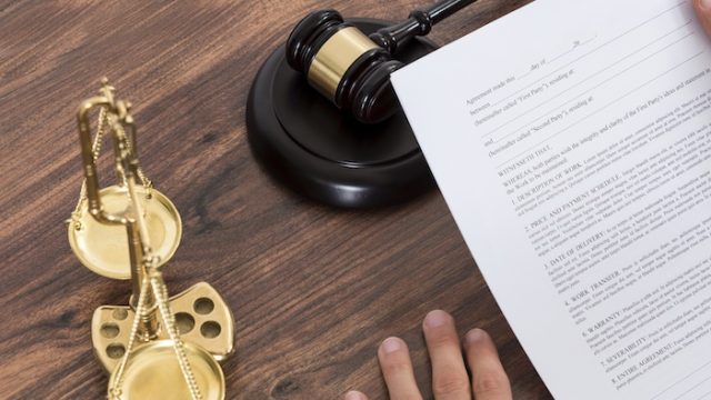 Close-up Of Male Judge Reading Paper In Courtroom